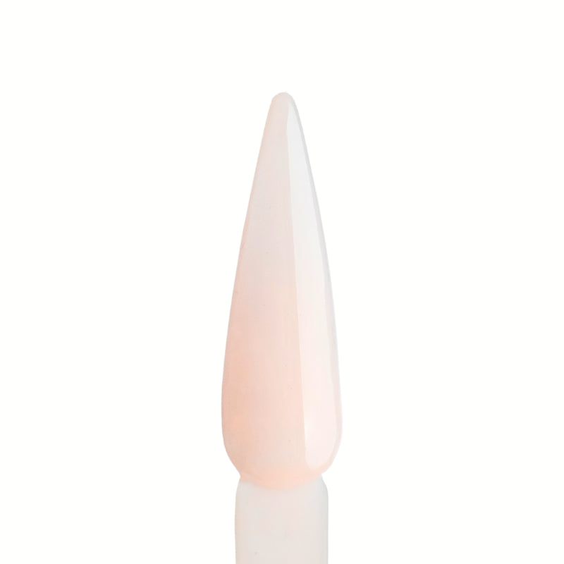 Swatch of Cover Soft Peach Acrylic Powder applied to a nail tip, showcasing its soft peach nude color for a natural, polished look.

